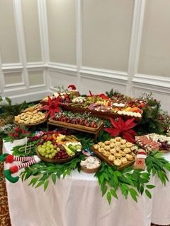Charcuterie board with diverse food items, including cheeses, meats, vegetables, and dips, on a festive table.