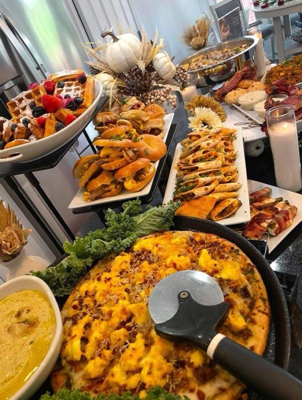 A table topped with plates of food and a pizza cutter.