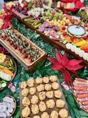 Close-up of appetizer bites on a wooden tray, decorated with a large red flower.