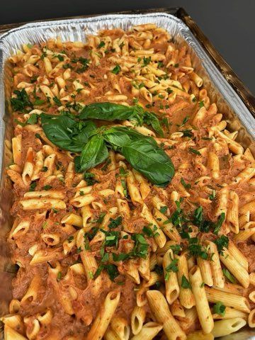 A casserole dish filled with pasta and sauce on a table.