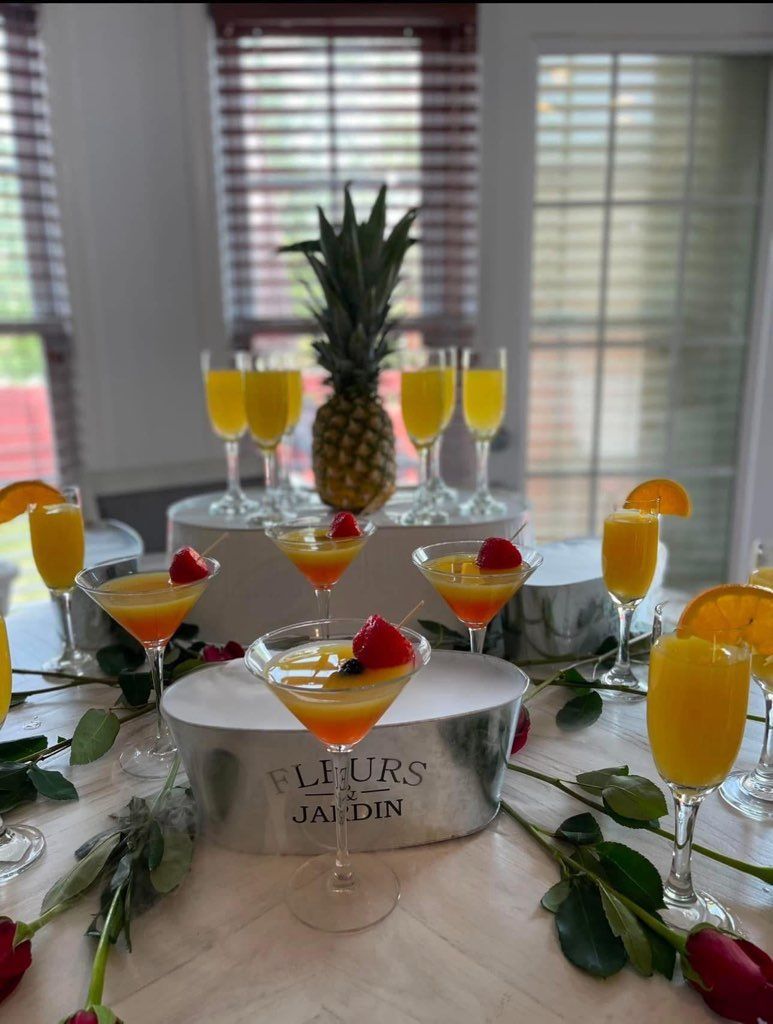 A table topped with glasses of orange juice and a pineapple.