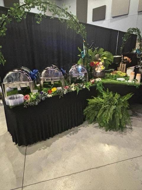 A buffet table with a black table cloth and a bunch of food on it