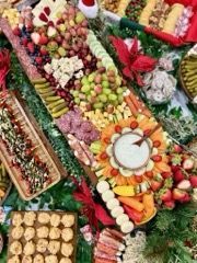Overhead shot of a holiday charcuterie board with a variety of fruits, cheeses, and crackers.