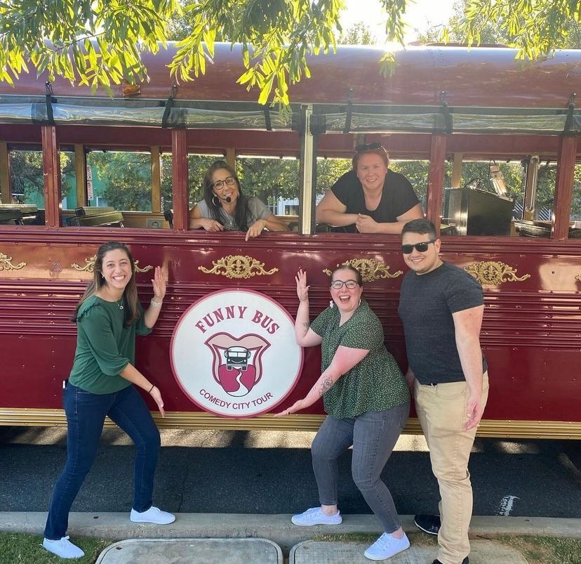 Group of people posing by a red 