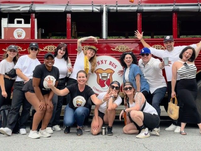 A group of people standing in front of a red bus having fun.
