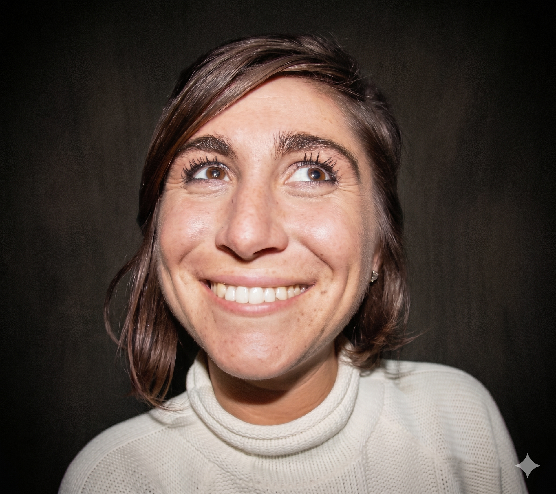 Man with glasses, surprised expression, looking up and to the right. Dark curly hair, black shirt, neutral background.