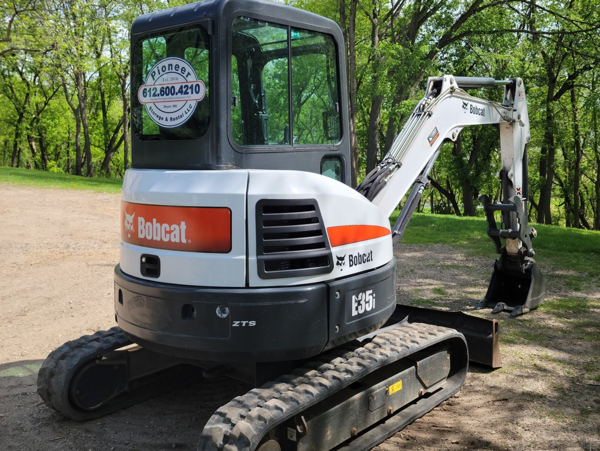 A bobcat excavator is parked on a dirt road