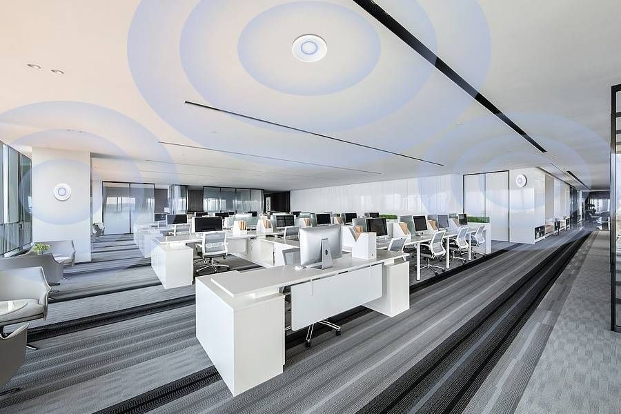 Modern office with multiple Wi-Fi mesh nodes providing seamless internet coverage across workstations