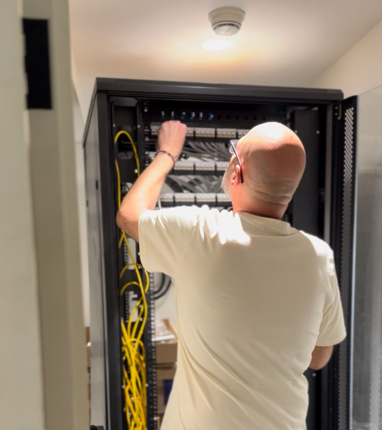 Network specialist wiring a structured cabling system inside a server cabinet – CALLIT IT INFRASTRUCTURE, Dubai