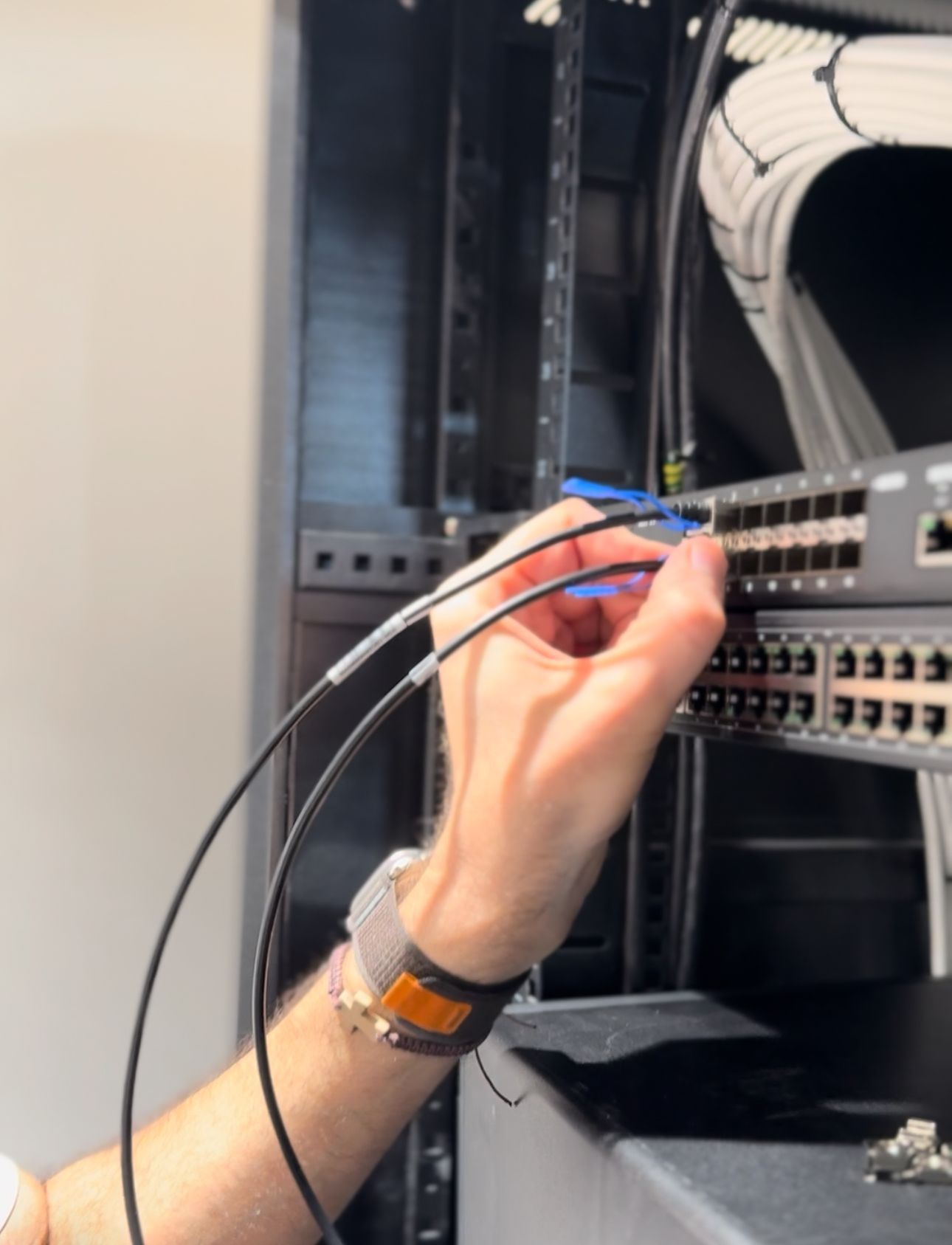 Fadi Helou connecting fiber uplink cables to a managed switch – CALLIT IT INFRASTRUCTURE Dubai UAE 100 Gbps network installation