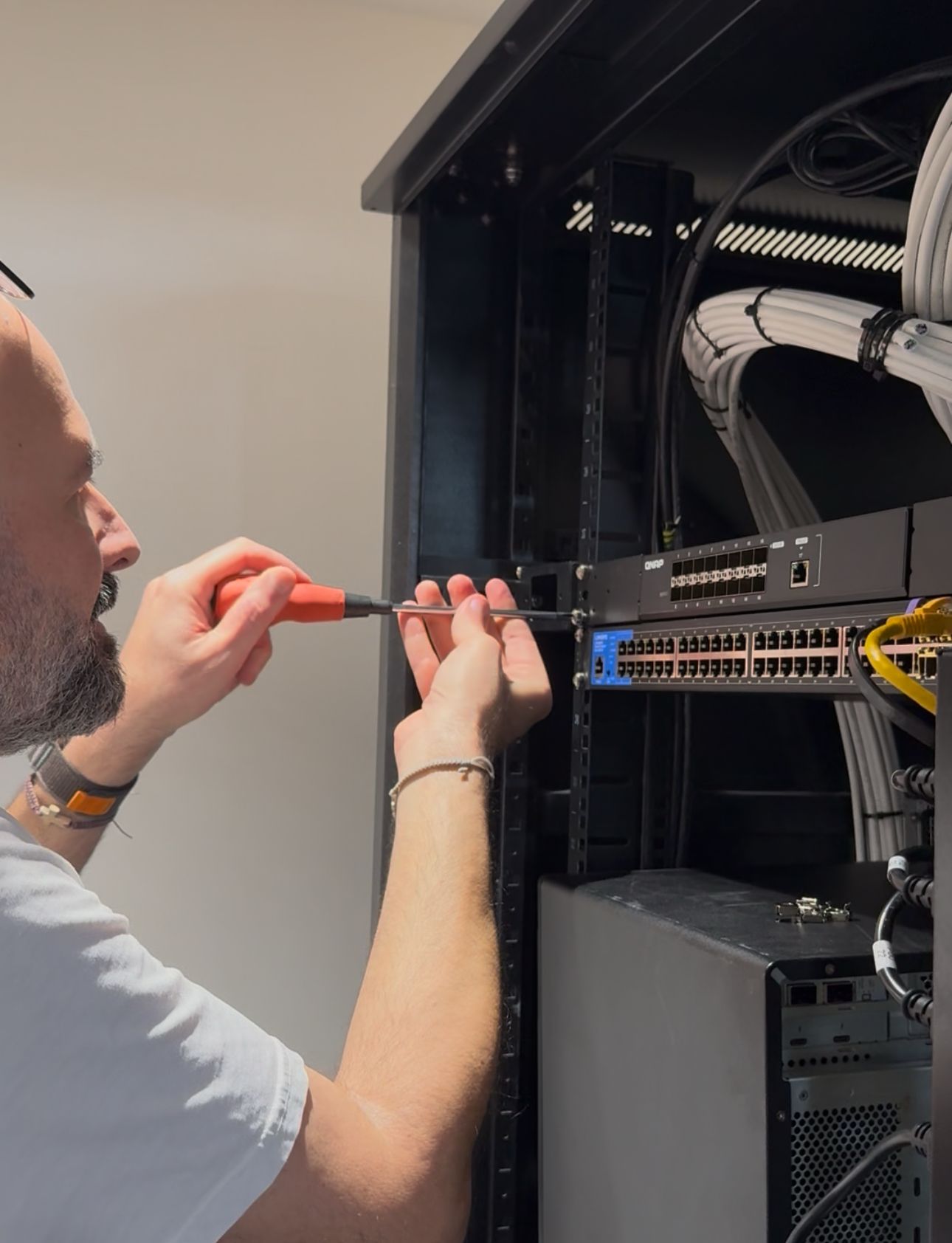 Fadi Helou, Network Infrastructure Specialist, performing professional cabinet installation and structured cabling setup in Dubai for enterprise-grade systems.