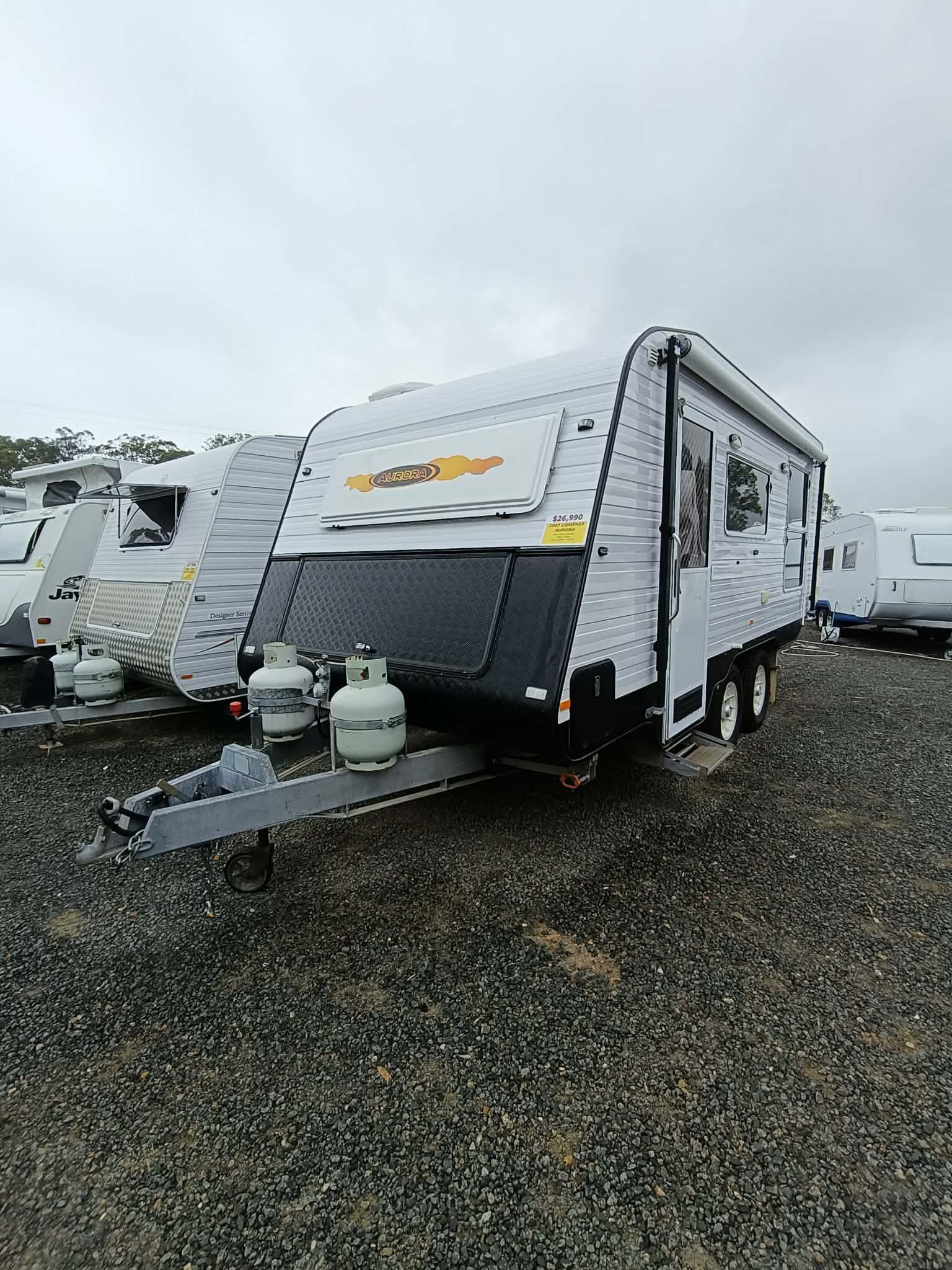 Grey and Black Travel Trailer Parked on Gravel, With Gas Tanks in Front — Great Lakes Caravans & RV P/L In Nabiac, NSW