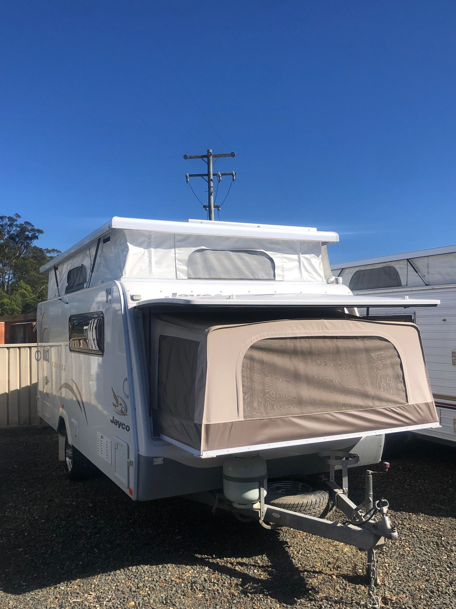 White Camper Trailer With Pop-up Roof and Awning — Great Lakes Caravans & RV P/L In Forster, NSW