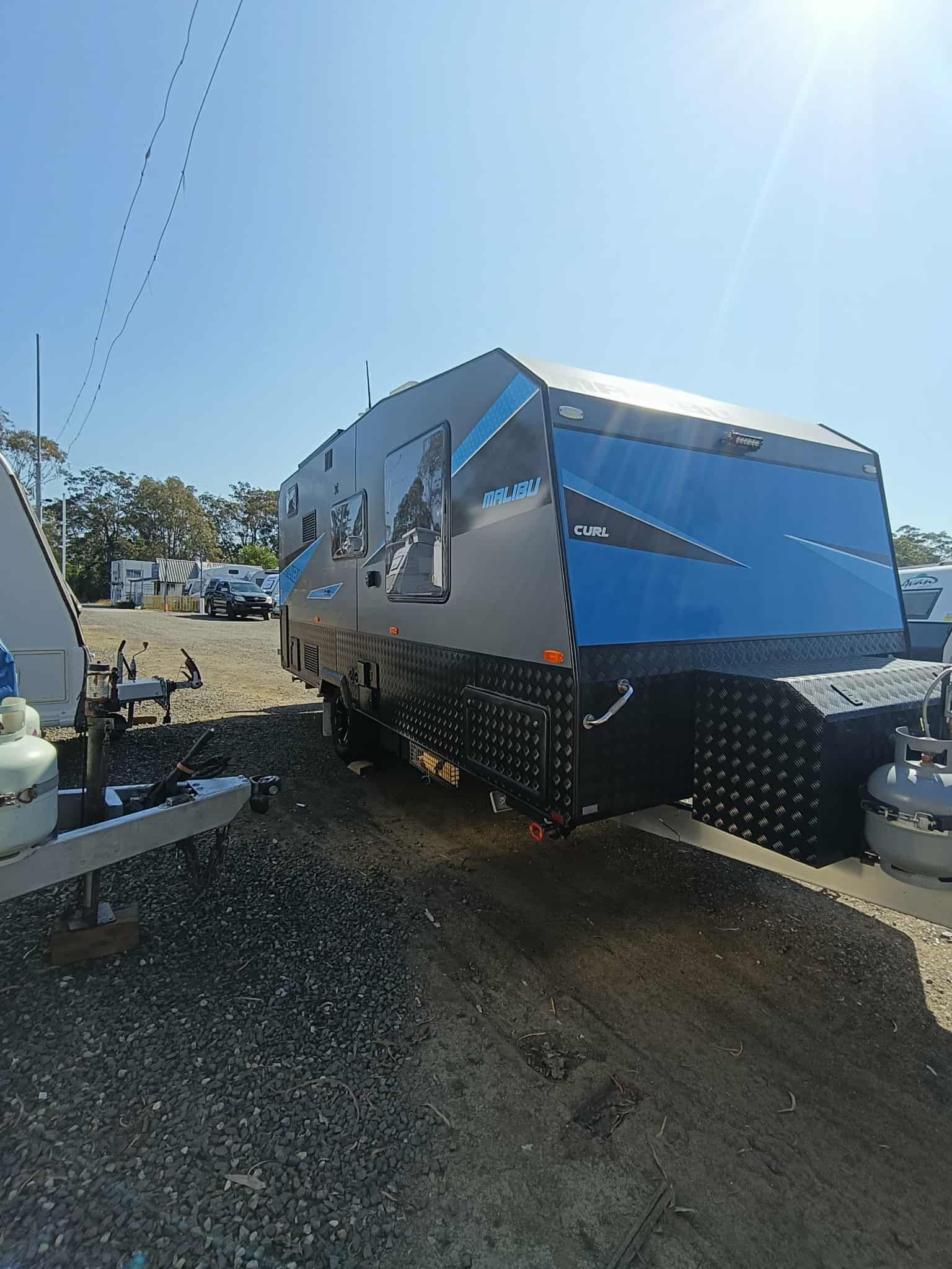 Dark Grey and Blue Caravan on a Gravel Lot — Great Lakes Caravans & RV P/L In Hunter Valley, NSW