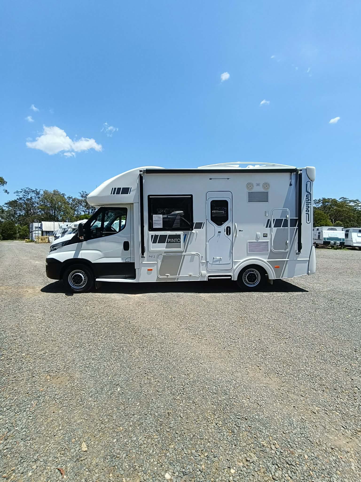 White RV Parked on Gravel Under a Blue Sky — Great Lakes Caravans & RV P/L In Forster, NSW