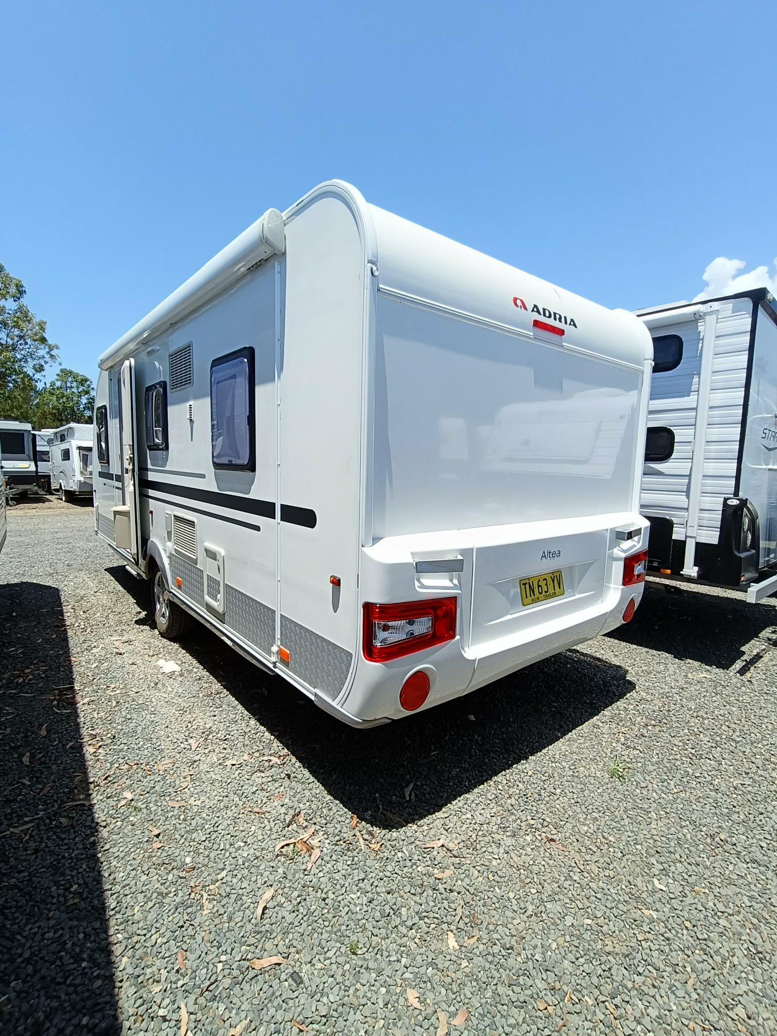 Camper Trailer Parked on Gravel Under a Blue Sky — Great Lakes Caravans & RV P/L In Nabiac, NSW