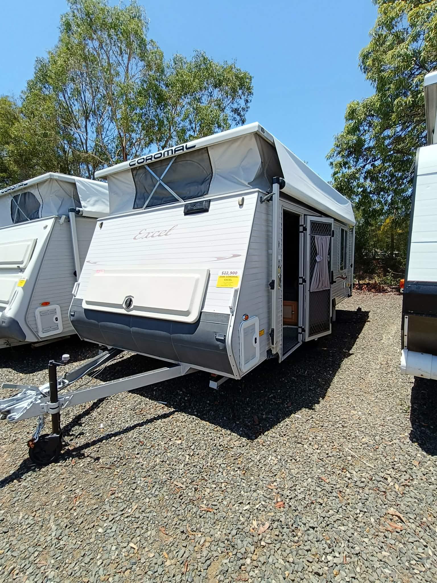Gray and White Pop-top Camper Trailer With an Open Door, Parked on Gravel — Great Lakes Caravans & RV P/L In Nabiac, NSW
