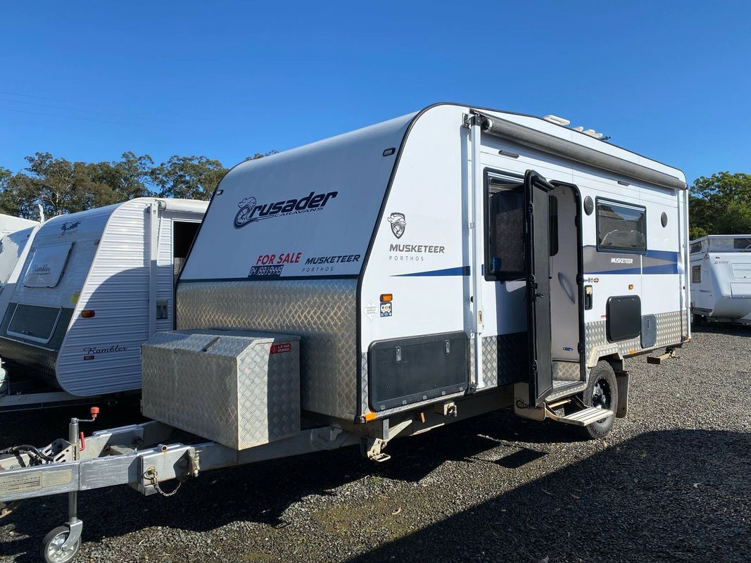 White and Blue Travel Trailer With Open Door, Parked Outdoors — Great Lakes Caravans & RV P/L In Nabiac, NSW