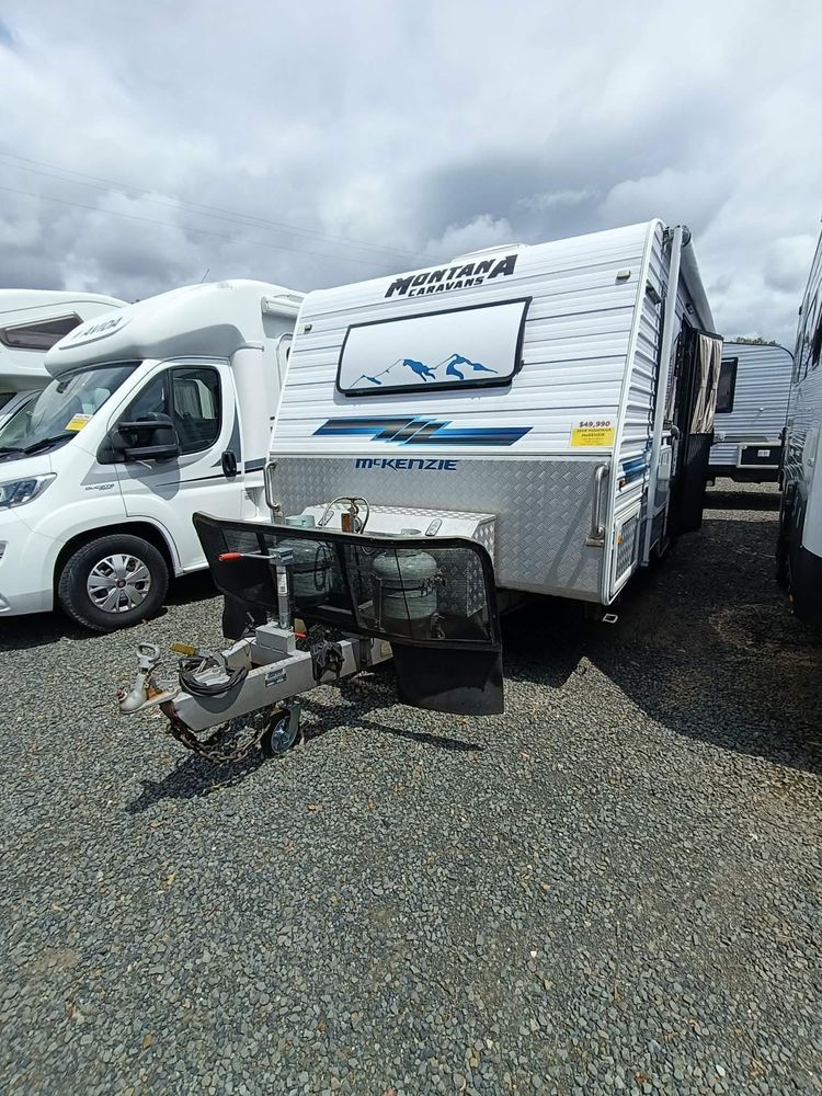 A White Montana Caravan Parked on Gravel, With a White Vehicle on Its Left  — Great Lakes Caravans & RV P/L In Nabiac, NSW