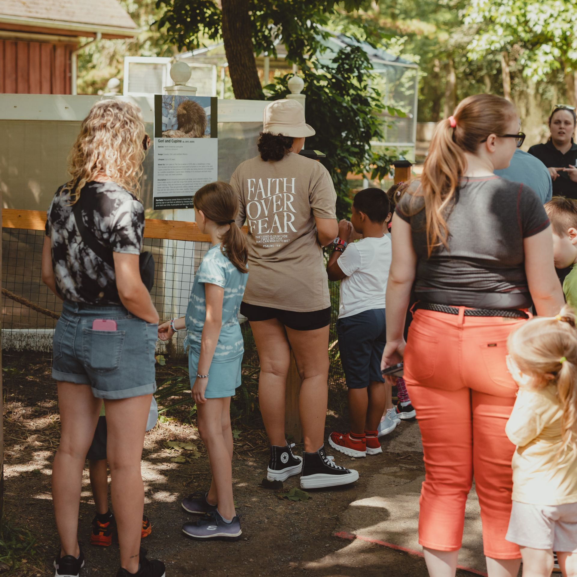 People standing in front of the porcupine exhibit at The Zoo.
