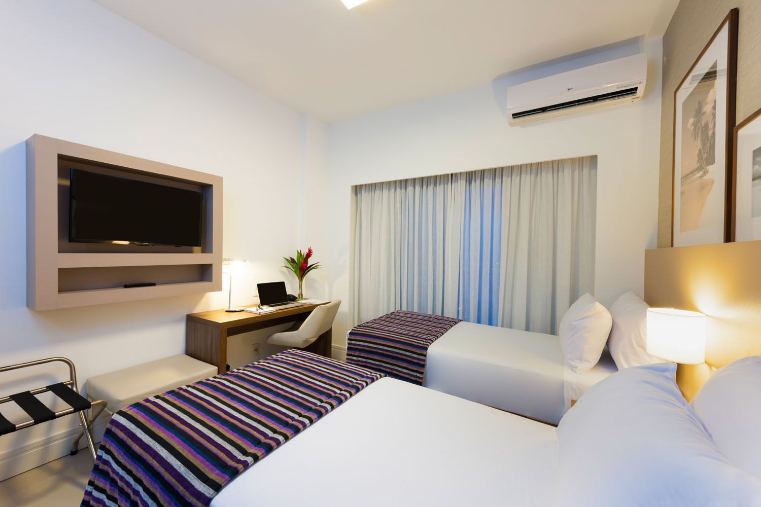 Um quarto de hotel com duas camas e uma TV de tela plana
