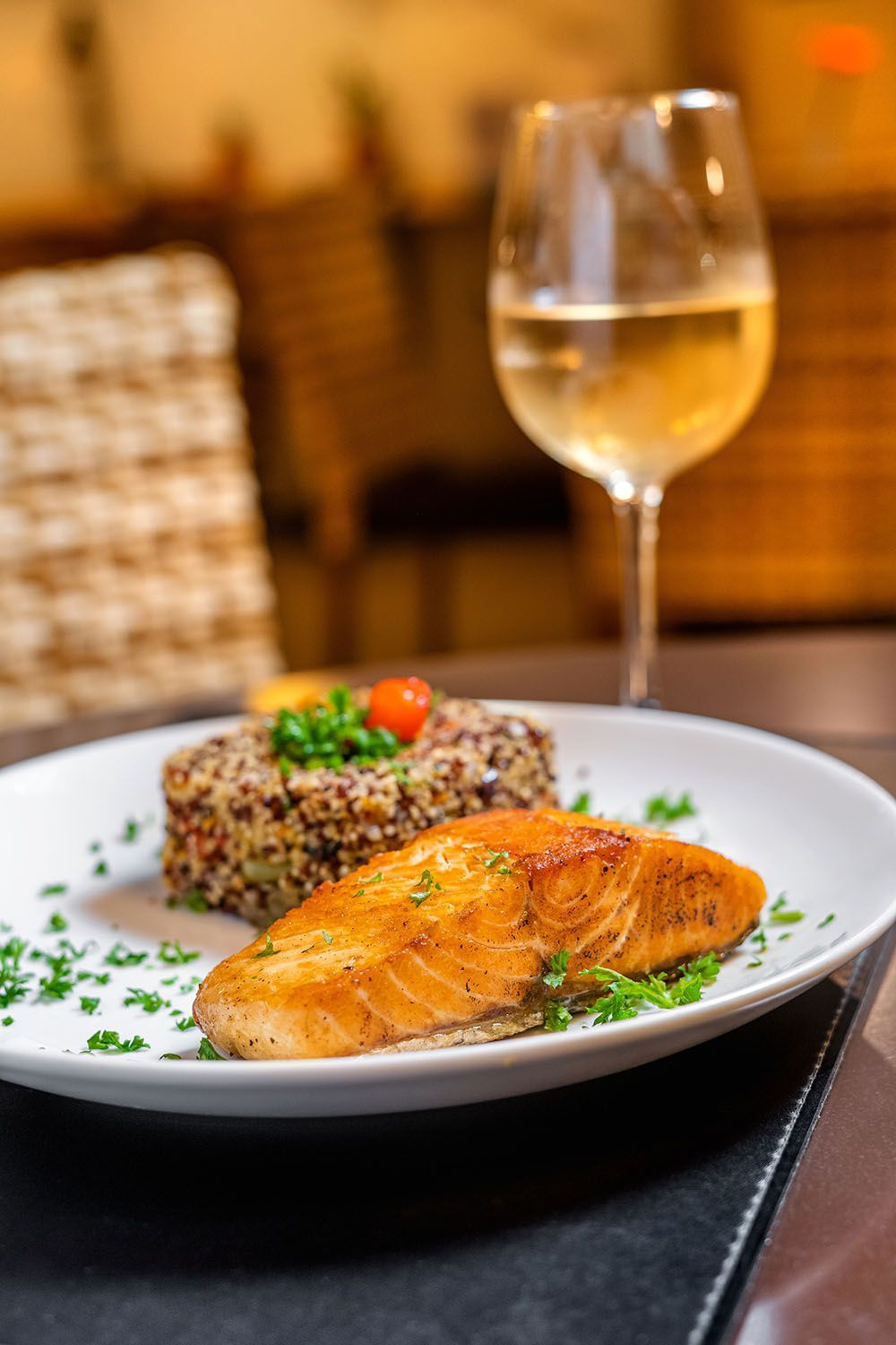 Um prato de comida com uma taça de vinho sobre a mesa.