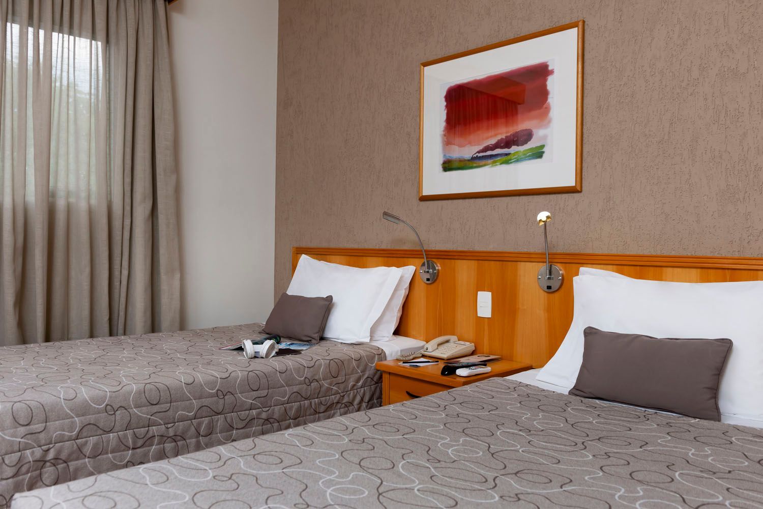 Um quarto de hotel com duas camas e uma foto na parede