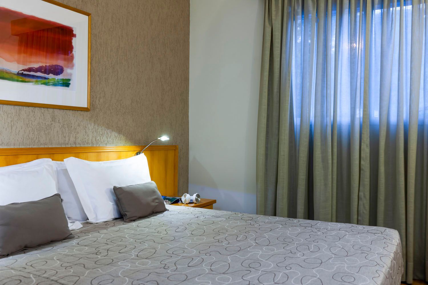 Um quarto de hotel com uma cama grande e uma janela.