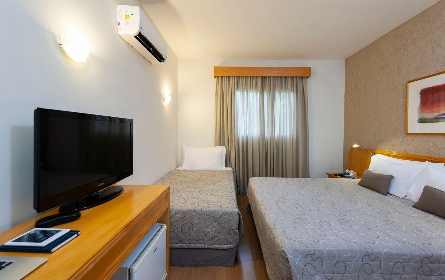 Um quarto de hotel com duas camas e uma TV de tela plana