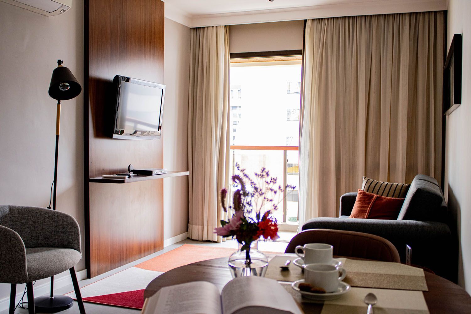 Uma sala de estar com uma mesa e cadeiras e um livro sobre a mesa