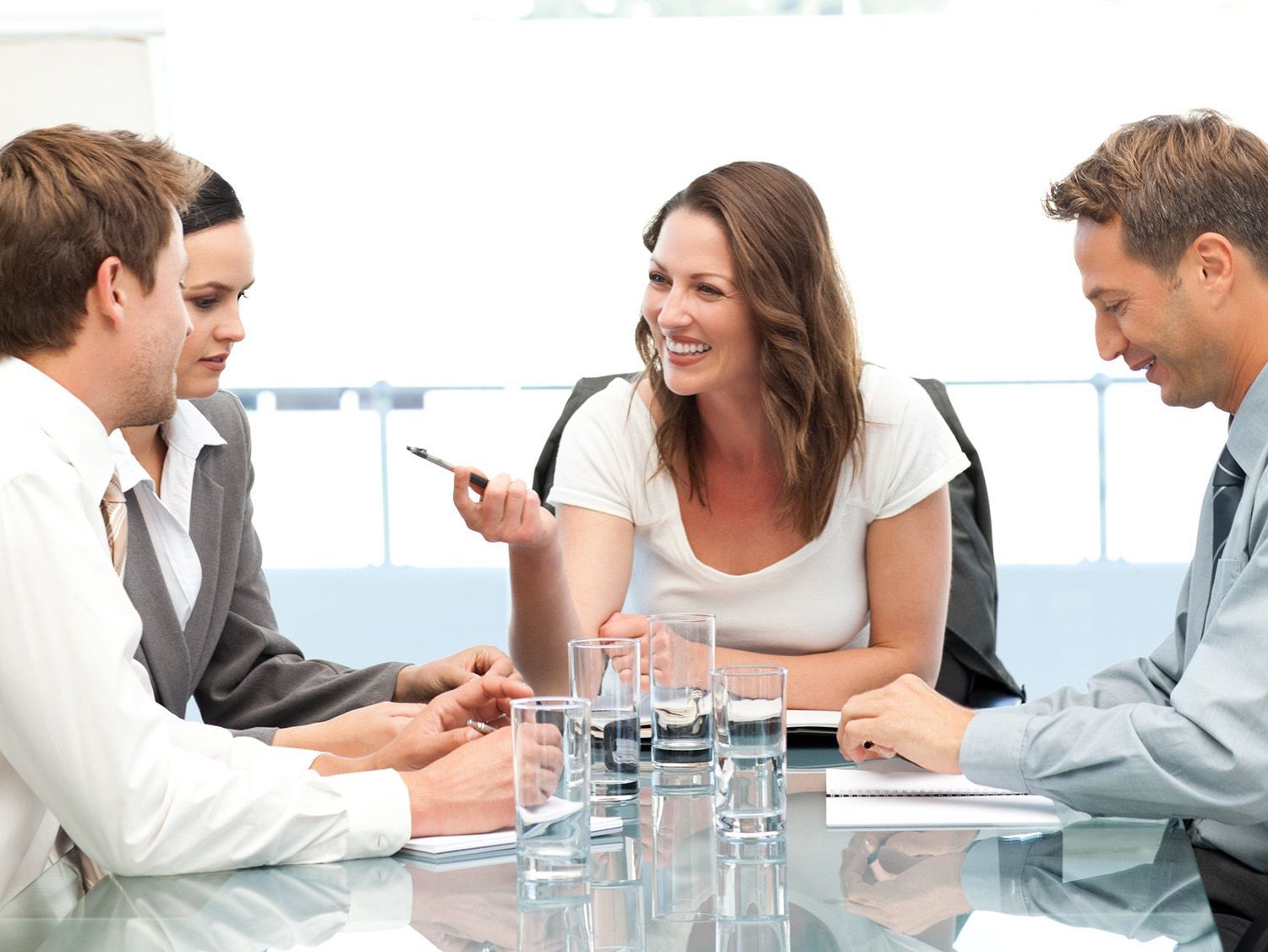 Um grupo de pessoas está de pé no saguão de um hotel com bagagem.