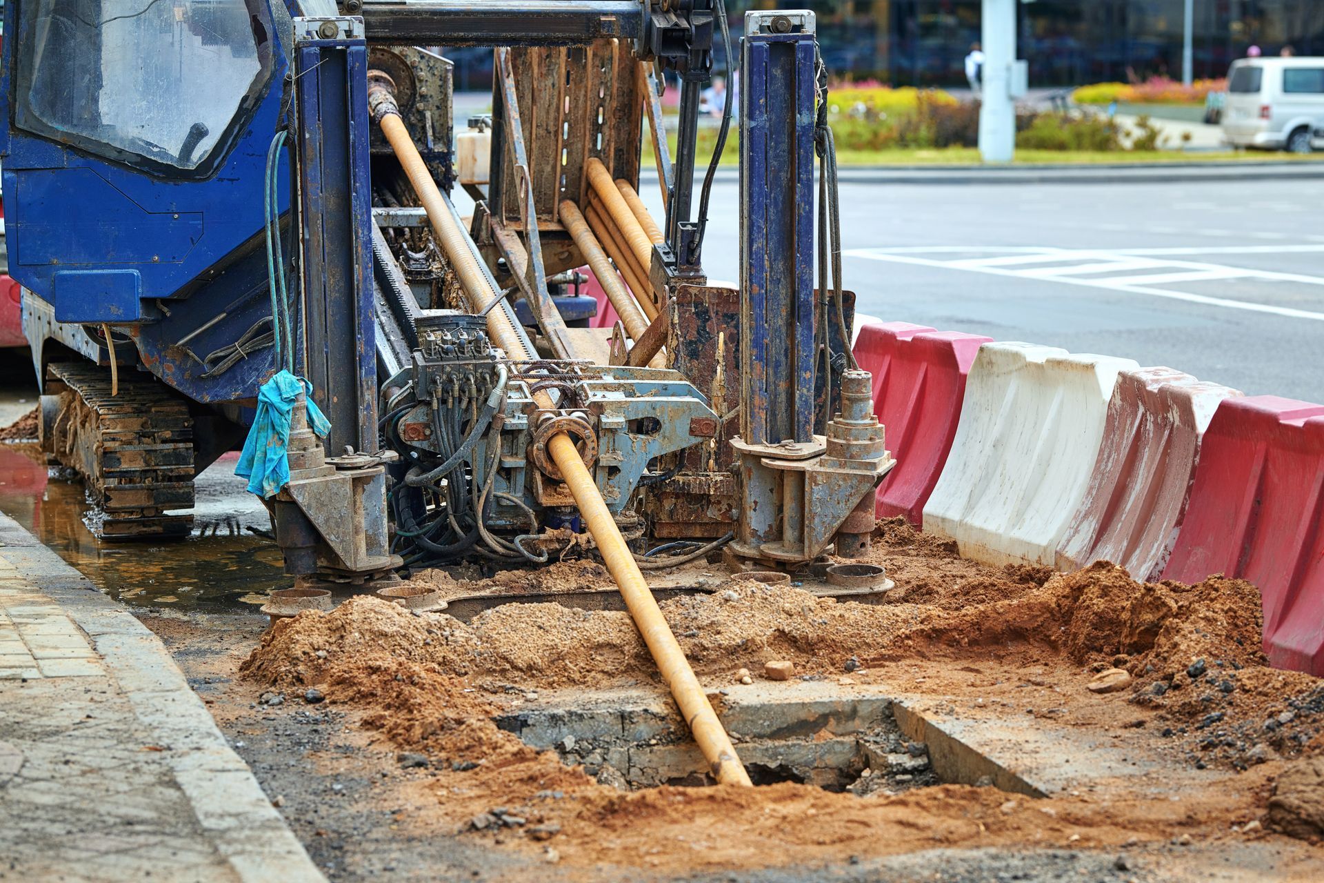 Drilling machine bores into ground next to a road