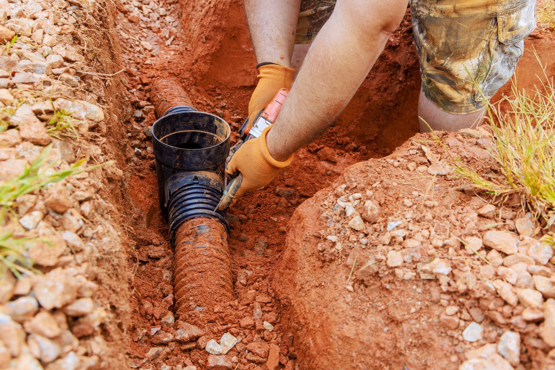 Person in gloves connecting corrugated drain pipe