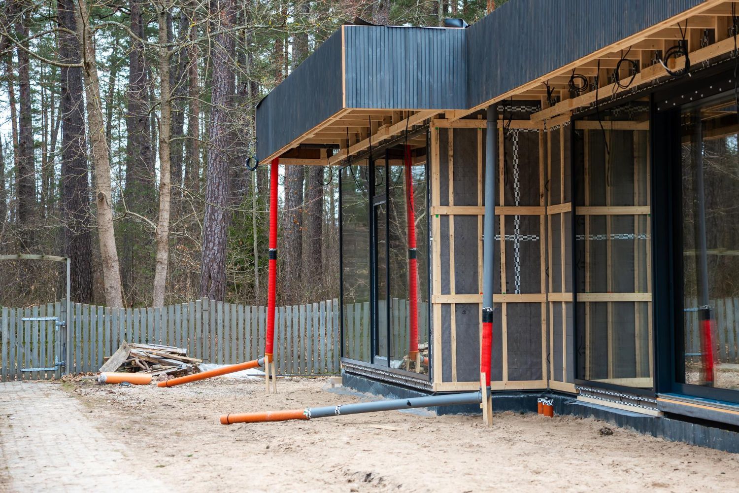 Wooden deck attached to a two-story house with green grass and a bright blue sky.