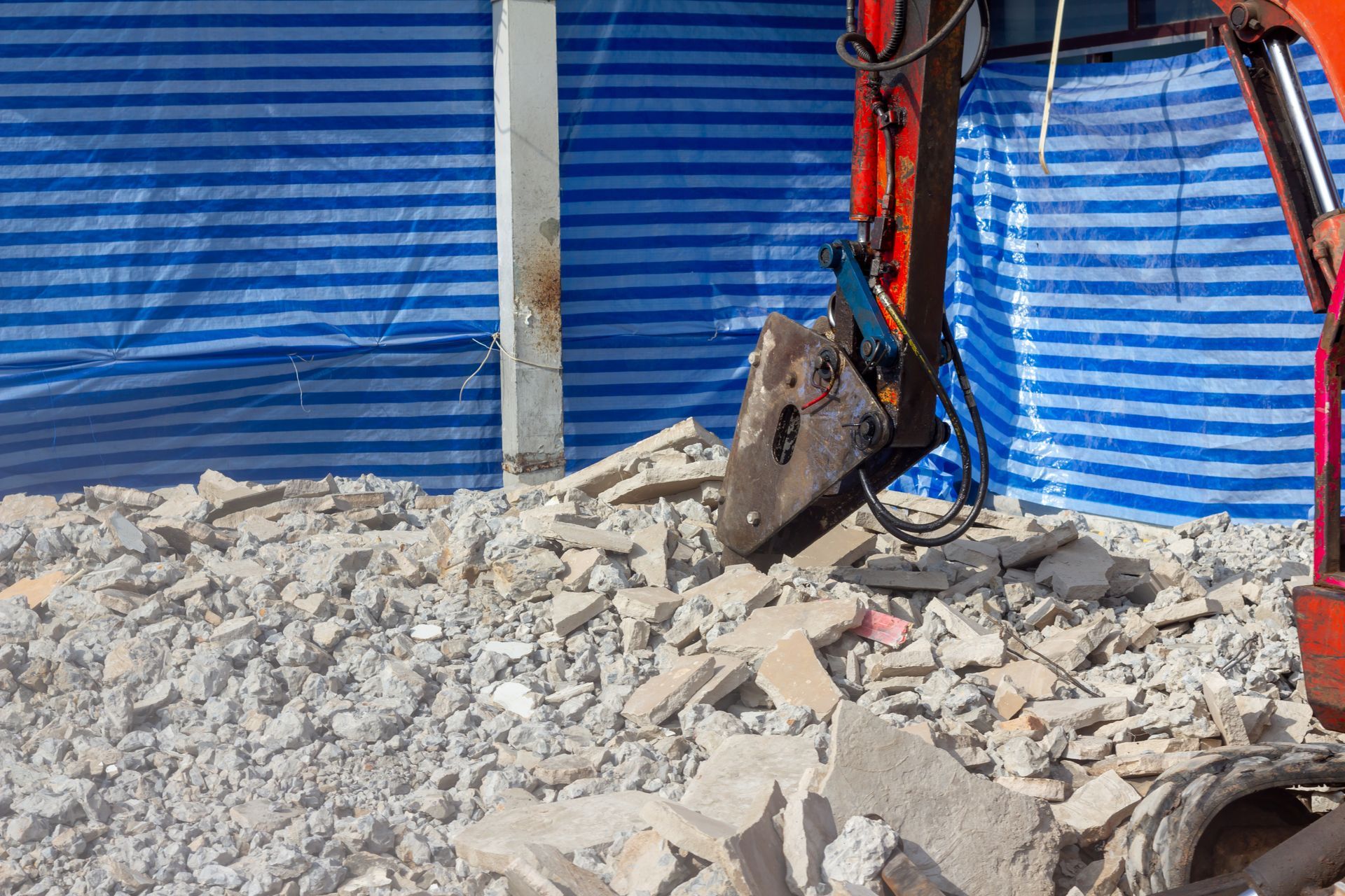 A bulldozer is breaking up concrete on a construction site.