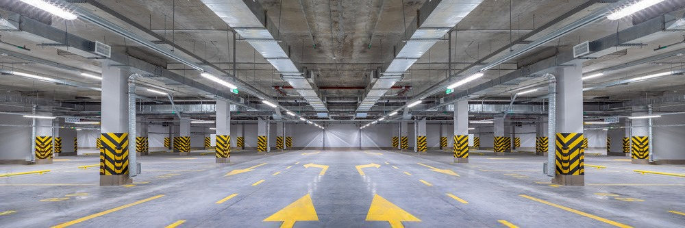 an empty parking garage with yellow arrows pointing in opposite directions .