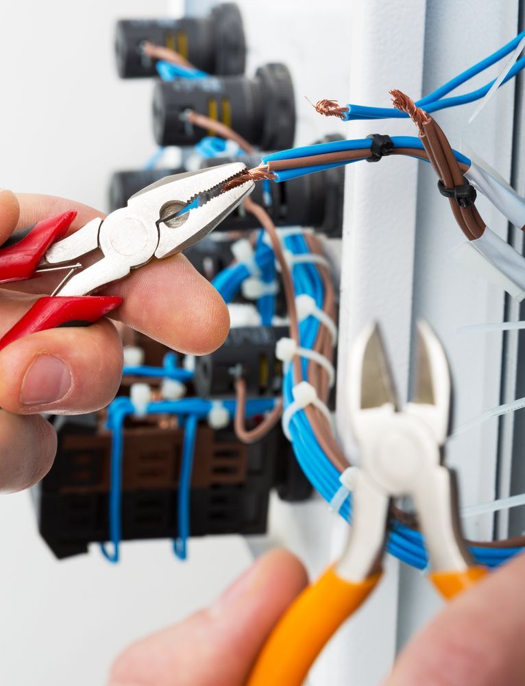 Hands Using Pliers to Strip Blue Electrical Wire — Cairns Excel Electrics In Earville, QLD