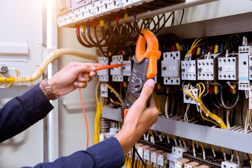 Technician Using a Multimeter to Test Wiring Inside an Electrical Control Panel — Cairns Excel Electrics In Mount Sheridan, QLD