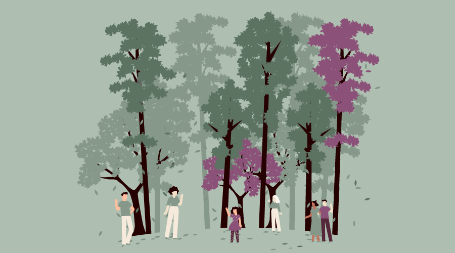 Eine Familie geht Händchen haltend einen Weg im Park entlang.