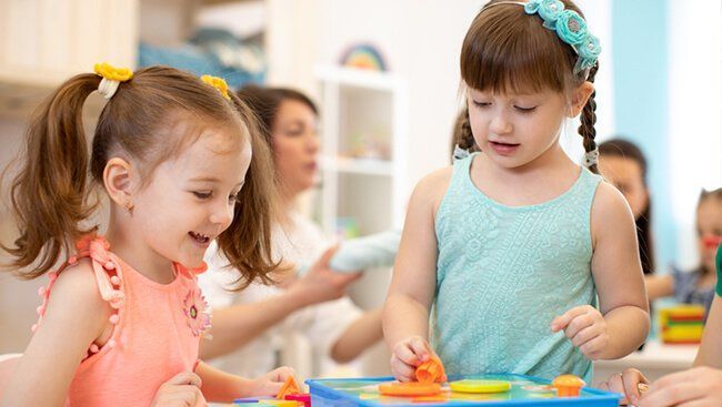 Montessori children are working with materials in a classroom.