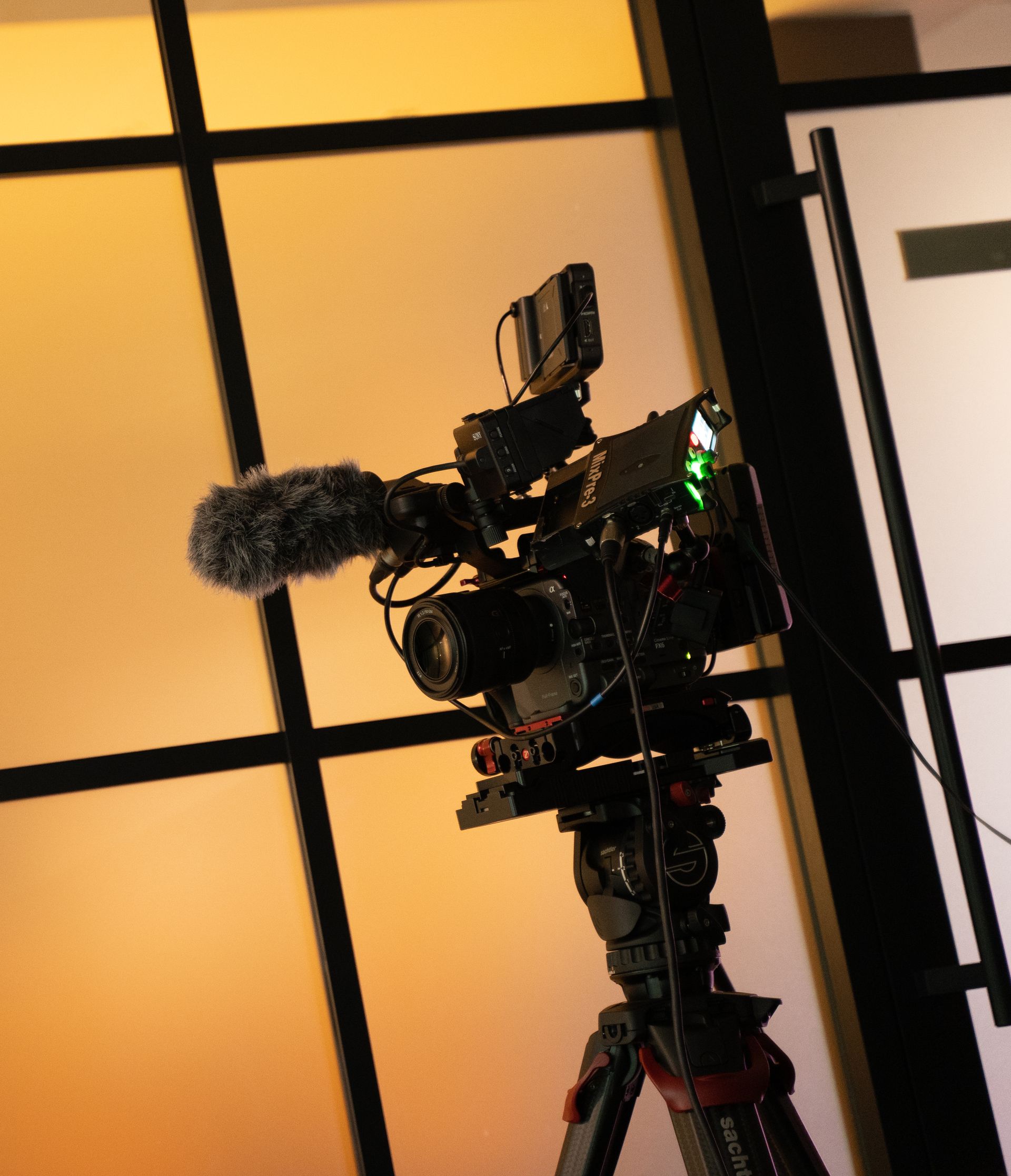 A camera on a tripod with a microphone attached to it