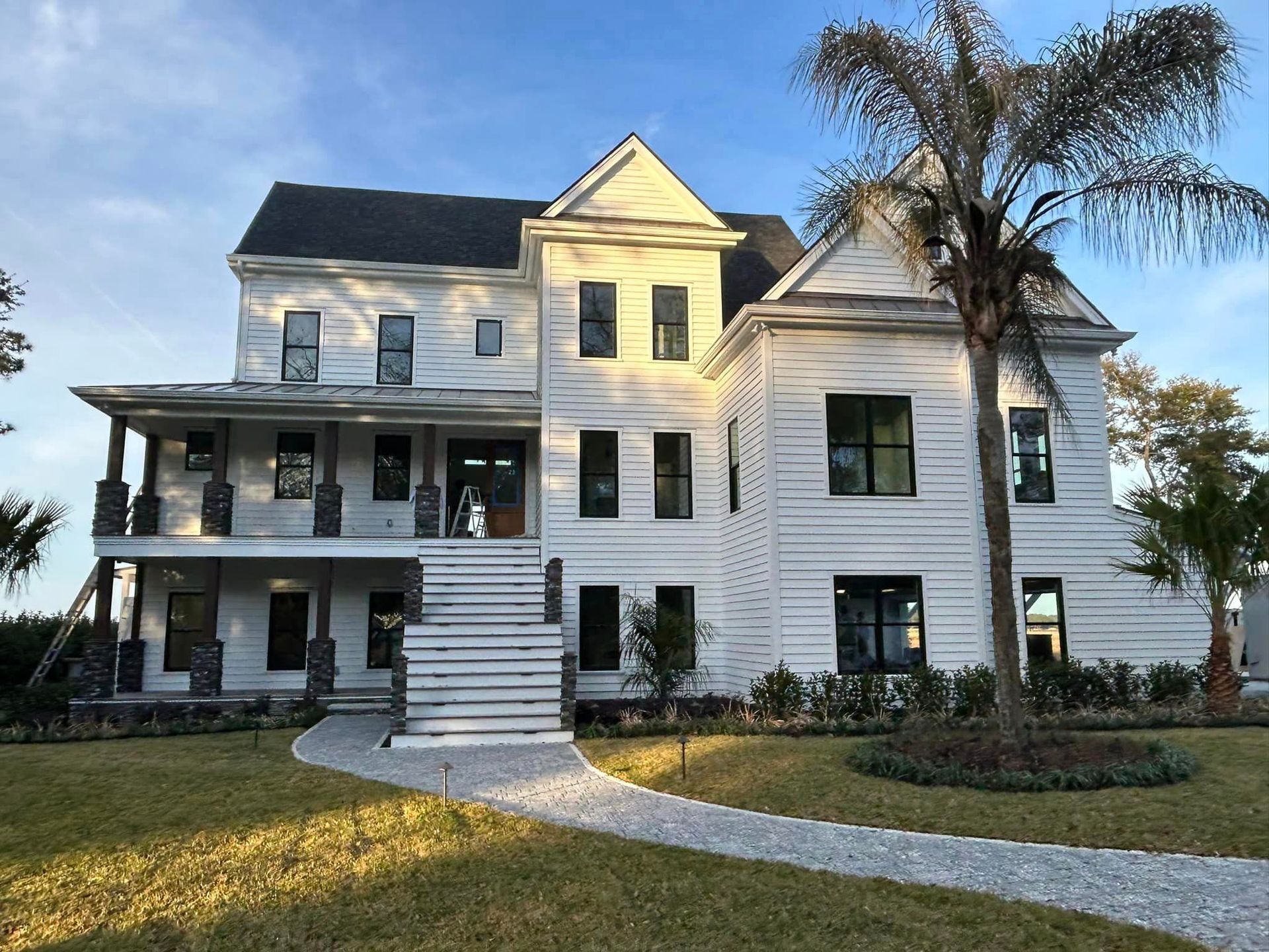 A Large White House With A Palm Tree In Front Of It — Richmond Hill, GA — A Plus
