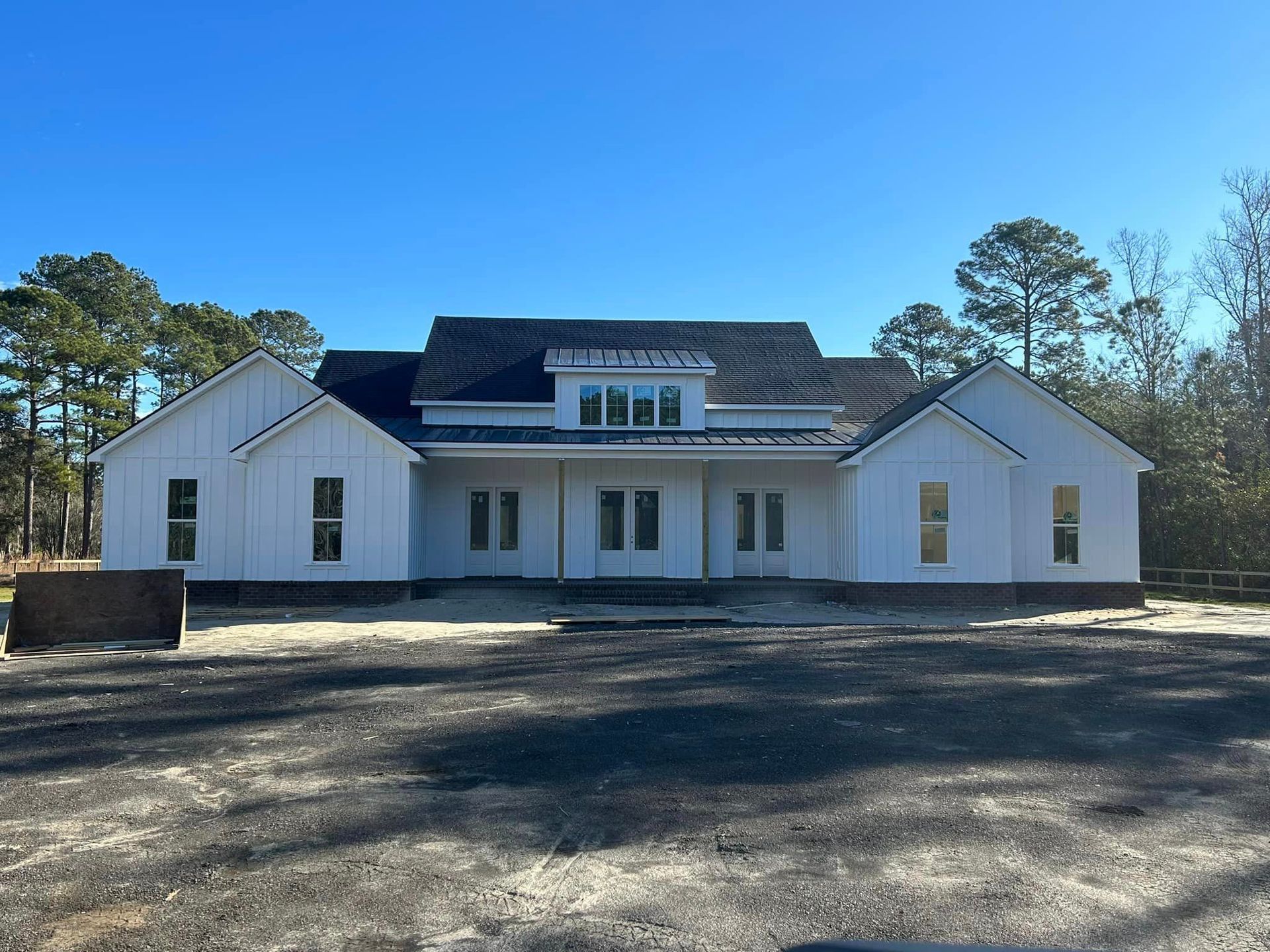 A White House With A Black Roof Is Under Construction — Richmond Hill, GA — A Plus