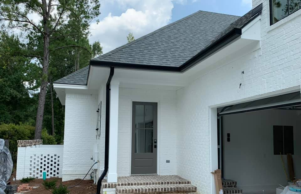 A White Brick House With A Black Garage Door — Richmond Hill, GA — A Plus