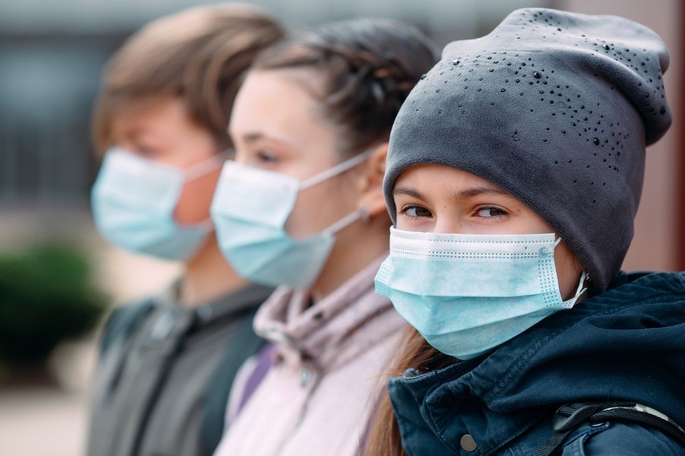 A group of people wearing face masks and hats.