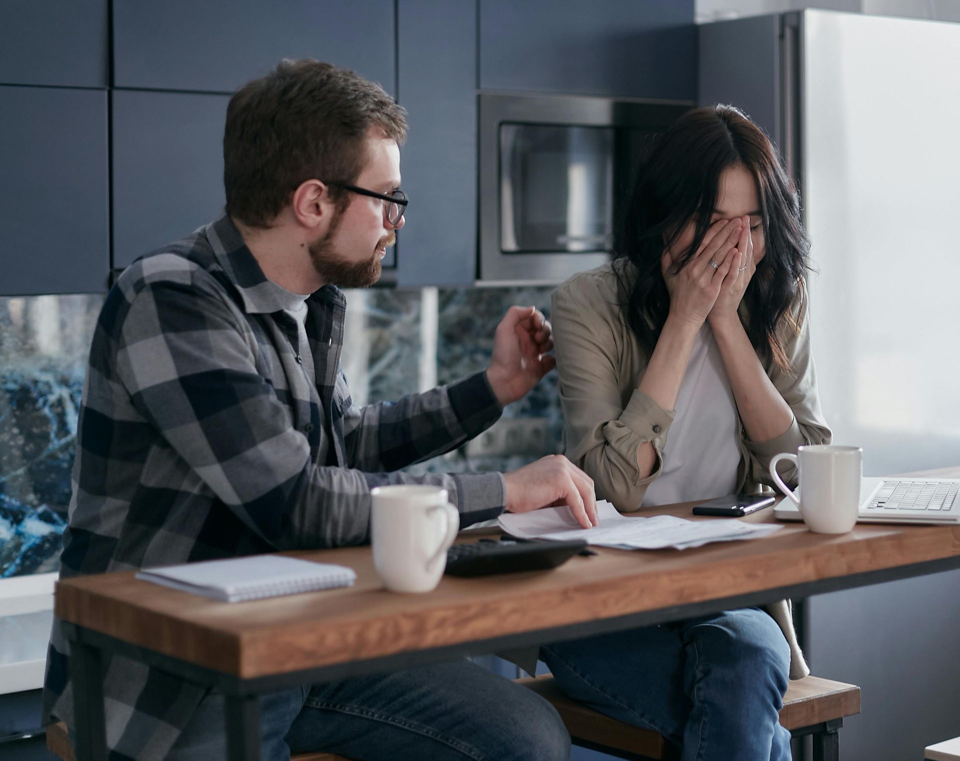 A man and a woman are sitting at a table looking at papers.