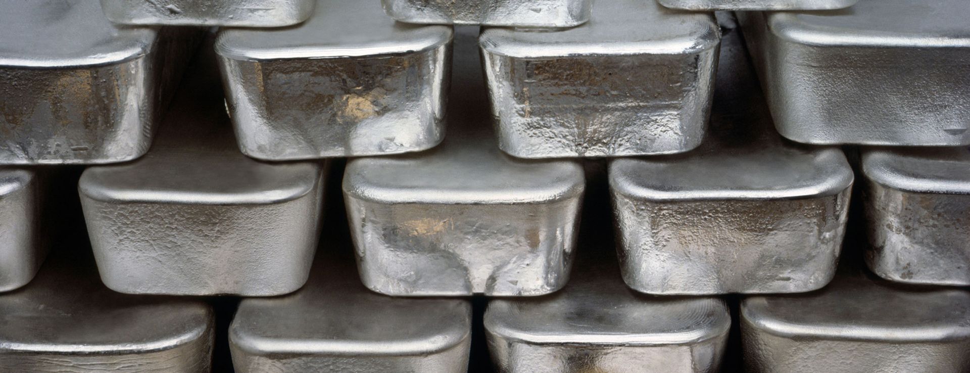 Stacked silver metal ingots in neat rows