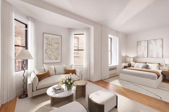 A living room with a couch , coffee table , and bed.