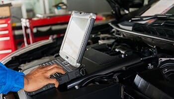 Man Repairing Car using laptop — electrical diagnostics in Cinnaminson, NJ
