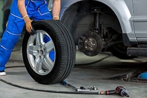 Man holding tires — brakes in Cinnaminson, NJ Man holding tires — brakes in Cinnaminson, NJ